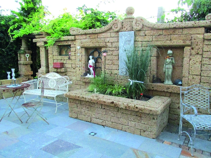 Mediterraner Gartenraum mit Tuffmauern und Natursteinboden