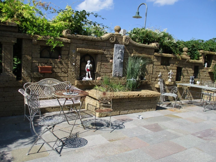 Gartenhof mit Tuffmauern und bepflanzten Nischen