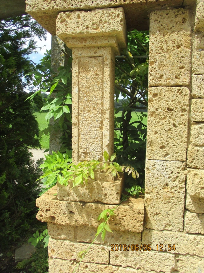 Fensteröffnung in einer begrünten Tuffmauer